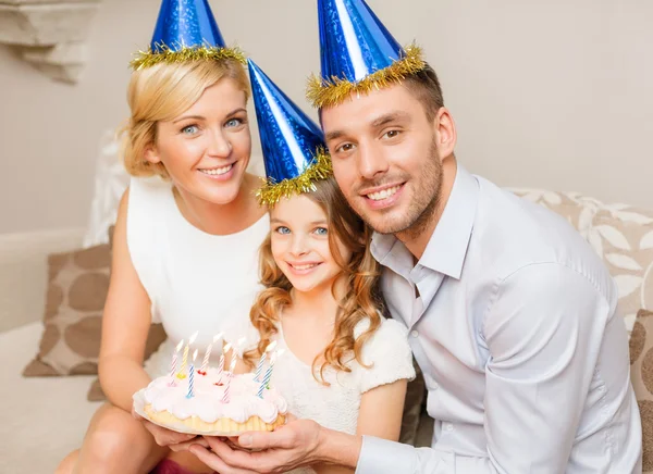 Familia sonriente en sombreros azules con pastel —  Fotos de Stock