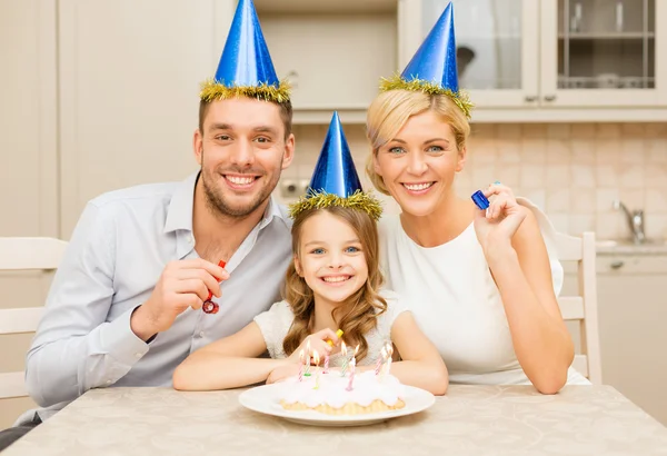 Lachende familie in blauwe hoeden gunst horens blazen — Stockfoto