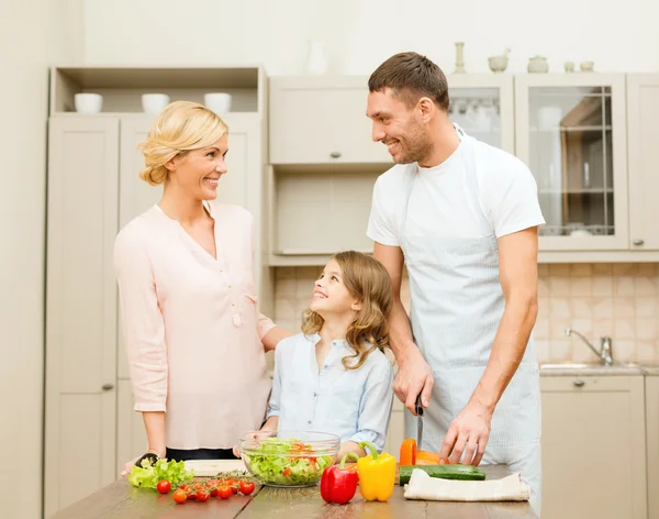 Feliz família fazendo o jantar na cozinha — Fotografia de Stock
