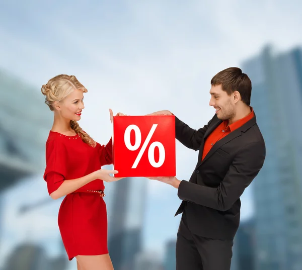 Mosolygó nő és férfi piros százalékos eladó jel — Stock Fotó