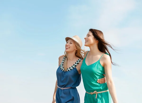 Lachende meisjes lopen op het strand — Stockfoto