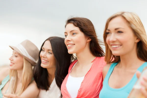 Ragazze sorridenti con bevande sulla spiaggia — Foto Stock