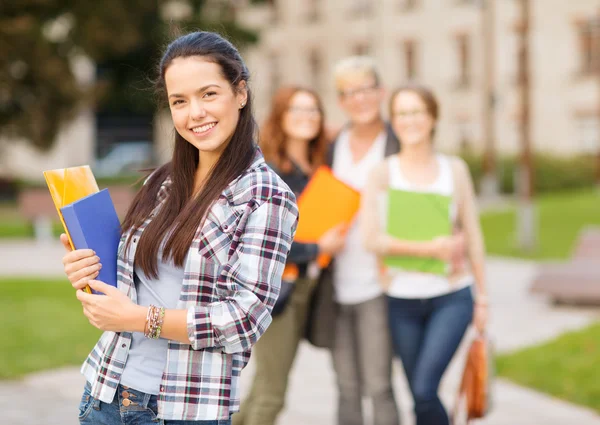 Teenage girl with folders and mates on the back — Stock Photo, Image