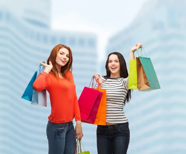 Two smiling teenage girls with shopping bags — Stock Photo, Image