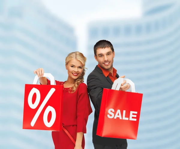 Hombre y mujer sonrientes con bolsa de compras —  Fotos de Stock