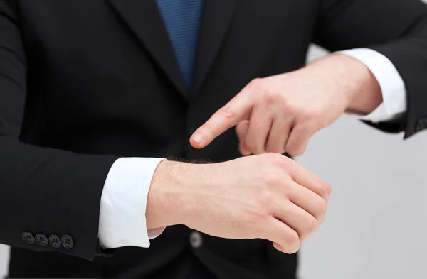 Businessman pointing to something at his hand — Stock Photo, Image