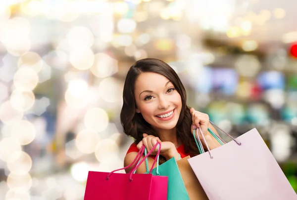 Woman in red dress with shopping bags — Stock Photo, Image