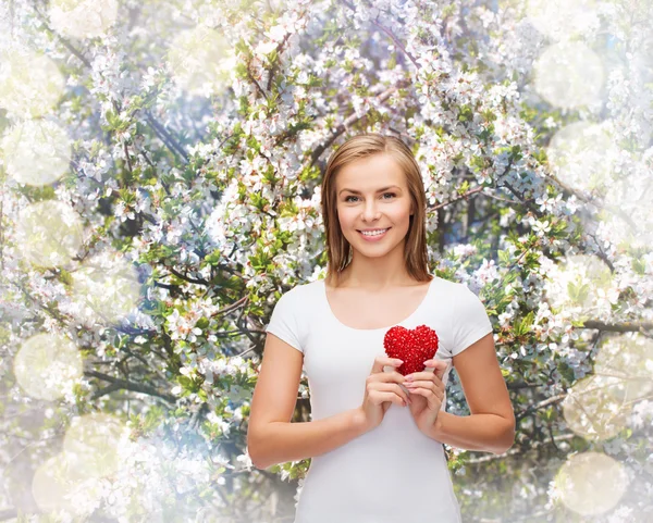 Lachende vrouw in wit t-shirt met hart — Stockfoto