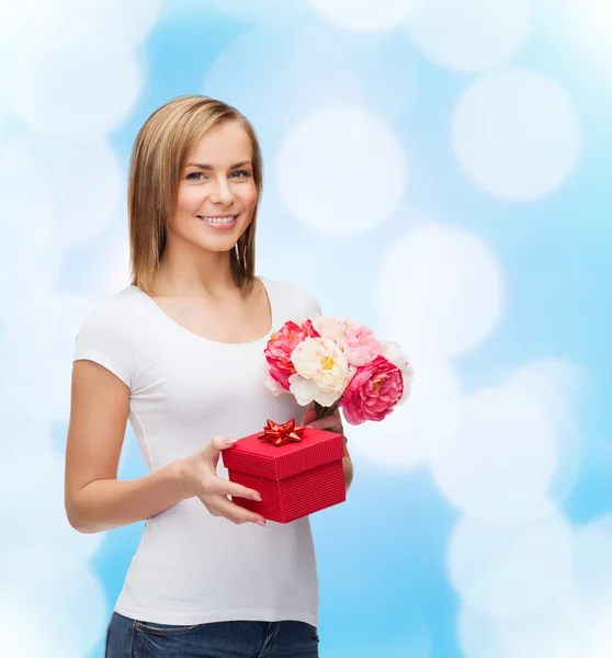 Smiling woman with bouquet of flowers and gift box — Stock Photo, Image