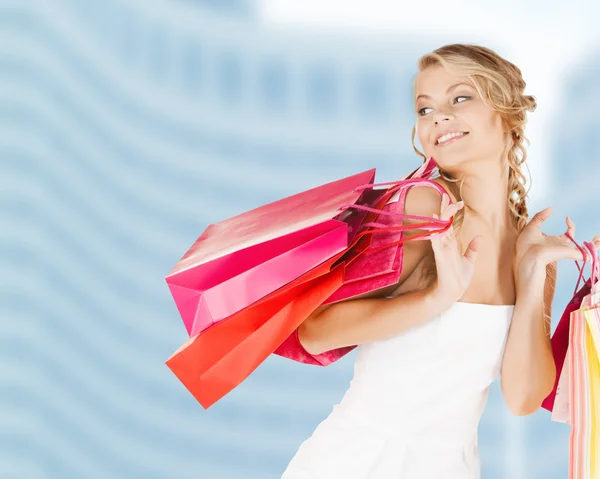 Mulher com sacos de compras em vestido — Fotografia de Stock