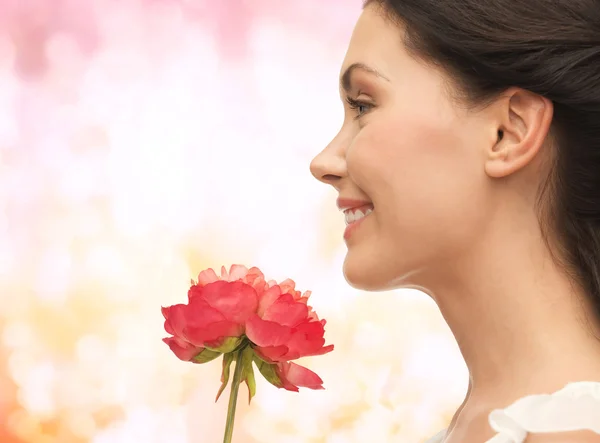 Улыбающаяся женщина, нюхающая цветы — стоковое фото