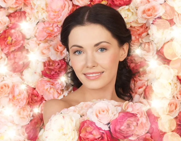 Woman with background full of roses — Stock Photo, Image