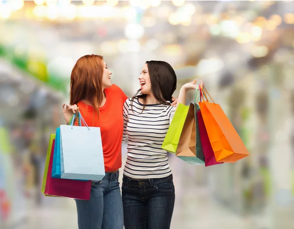 Twee glimlachend tienermeisjes met shopping tassen — Stockfoto