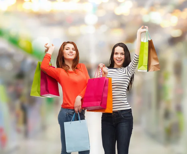 Duas meninas adolescentes sorridentes com sacos de compras — Fotografia de Stock