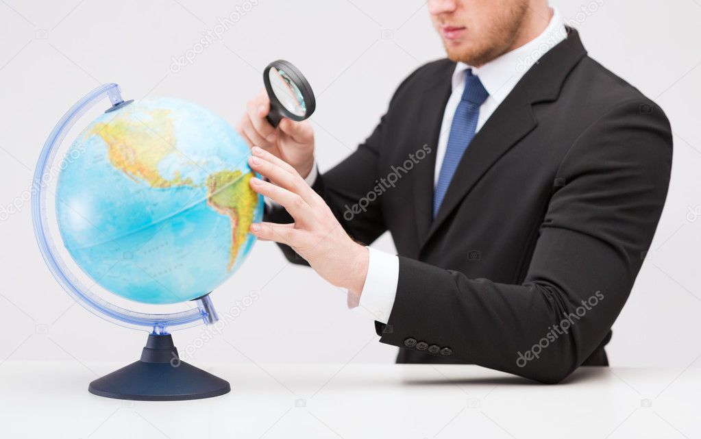 地球上のビジネスマン手拡大鏡 ストック写真 C Syda Productions