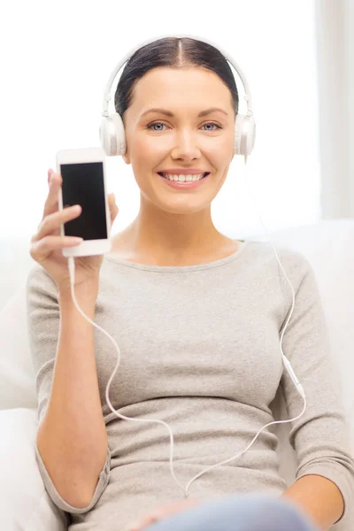 Mujer con smartphone y auriculares en casa —  Fotos de Stock