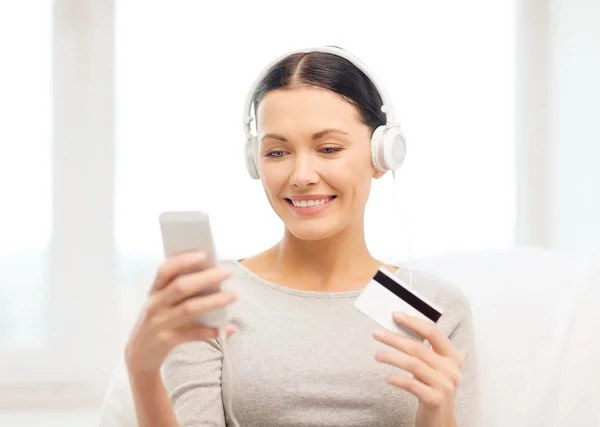 Mujer con smartphone y auriculares en casa —  Fotos de Stock