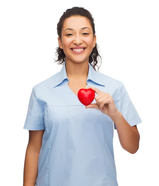 Улыбающаяся женщина-врач или медсестра с сердцем — стоковое фото