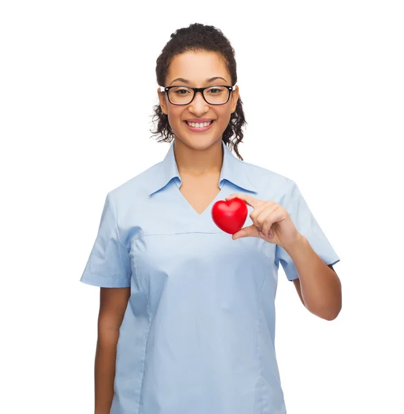 Sorridente medico femminile o infermiere con cuore — Foto Stock