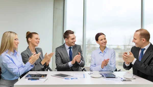 Business team with laptop clapping hands — Stock Photo, Image