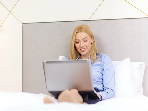 Feliz mujer de negocios con portátil en la habitación de hotel —  Fotos de Stock