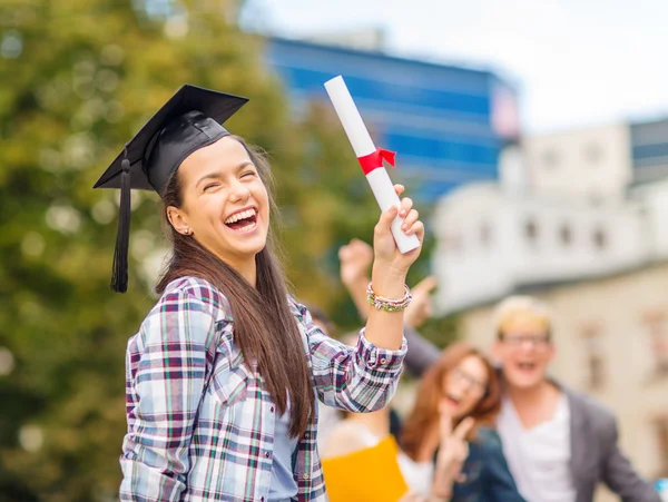 Menina adolescente sorridente em boné de canto com diploma — Fotografia de Stock