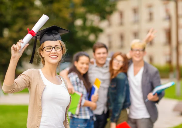 Sonriente adolescente en gorra de esquina con diploma —  Fotos de Stock