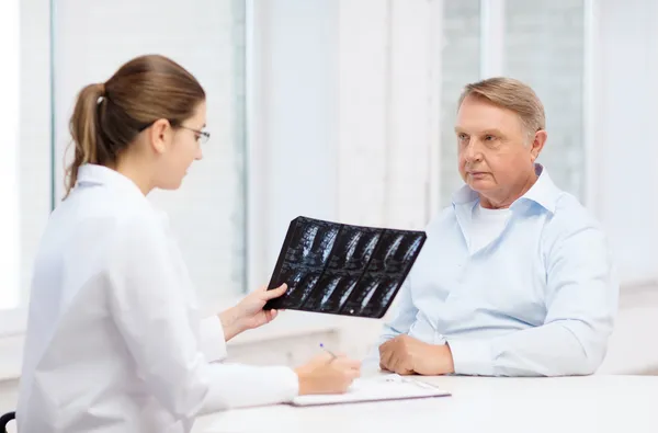 Doctora con anciano mirando rayos X —  Fotos de Stock