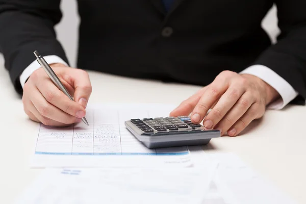 Close up of businessman with papers and calculator Stock Picture