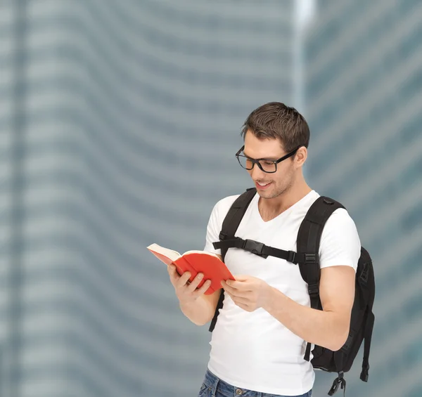 Estudante em óculos com mochila e livro — Fotografia de Stock