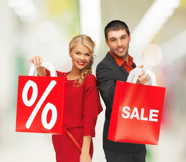 Hombre y mujer sonrientes con bolsa de compras — Foto de Stock