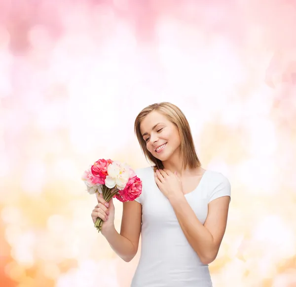 Femme souriante avec bouquet de fleurs — Photo