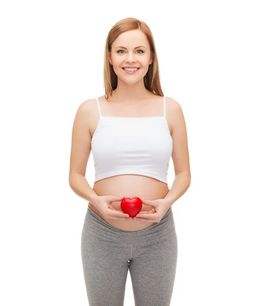 Glückliche zukünftige Mutter mit kleinem roten Herz — Stockfoto