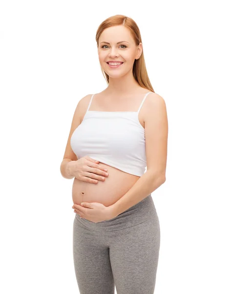 Glückliche zukünftige Mutter, die ihren Bauch berührt — Stockfoto