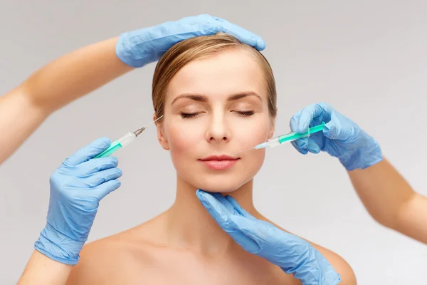 Woman face and beautician hands with syringe — Stock Photo, Image