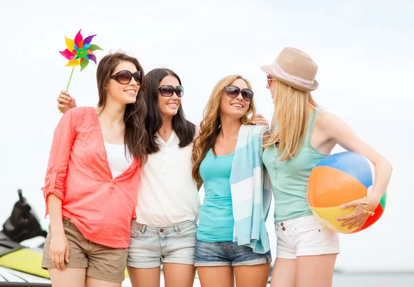 Lachende meisjes in tinten plezier op het strand — Stockfoto