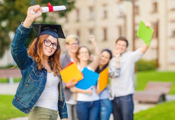 Lächelndes Teenie-Mädchen in Zipfelmütze mit Diplom — Stockfoto