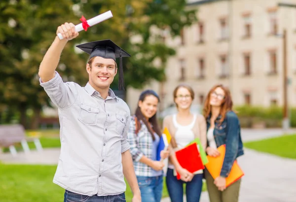 Lachende tiener in hoek-cap met diploma — Stockfoto