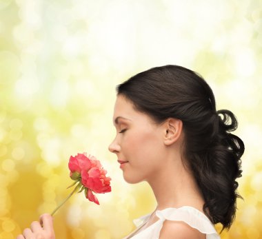 Smiling woman smelling flower clipart