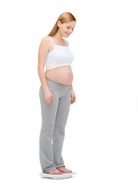 Szczęśliwa kobieta w ciąży waga sama — Zdjęcie stockowe