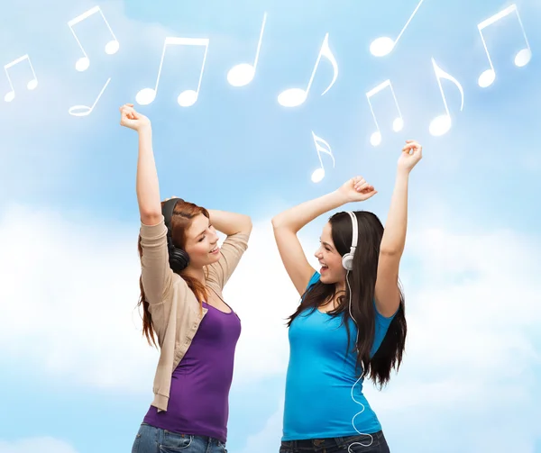 Deux filles riantes avec écouteurs dansant — Photo