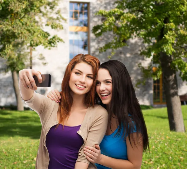 Dwóch nastolatków uśmiechający się z smartphone — Zdjęcie stockowe