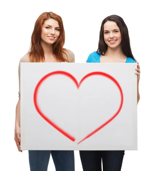 Two smiling young girls with blank white board — Stock Photo, Image