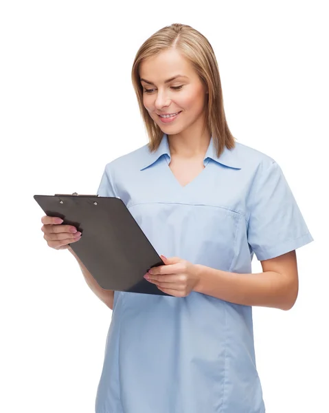 Smiling female doctor or nurse with clipboard — Stock Photo, Image