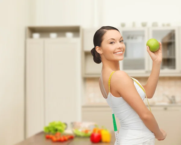 Sporty woman with apple and measuring tape — Stok fotoğraf