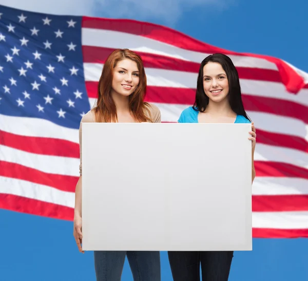 Due giovani ragazze sorridenti con bordo bianco bianco — Foto Stock