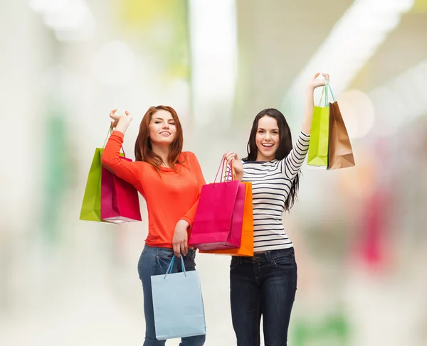 Two smiling teenage girls with shopping bags — Stock Photo, Image