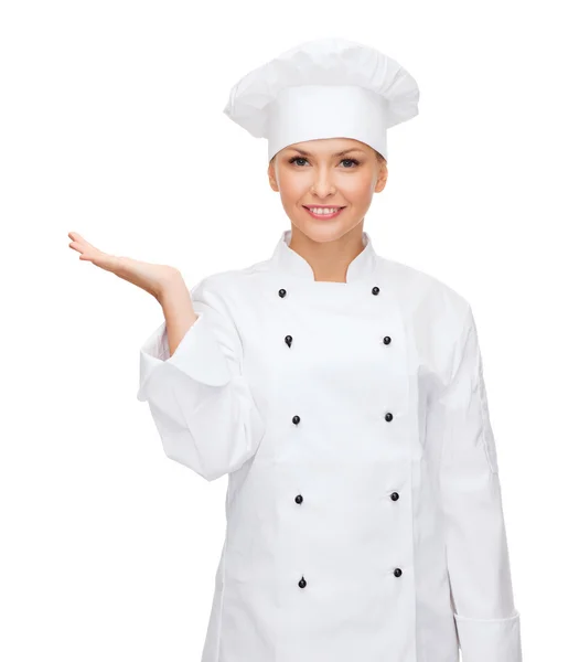 Smiling female chef holding something on hand — Stock Photo, Image