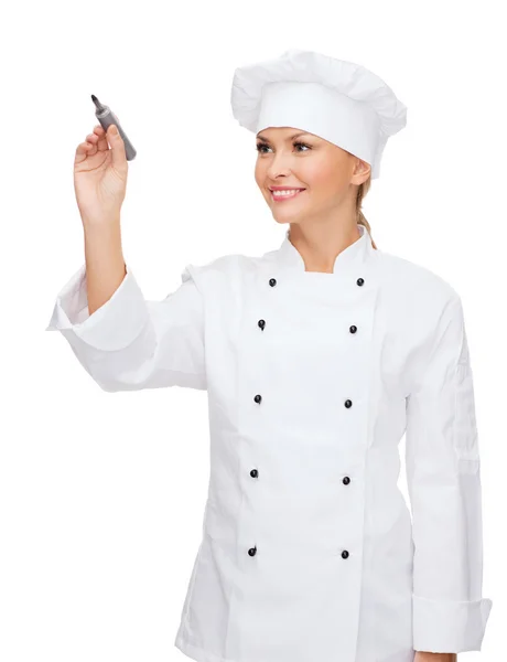 Sorrindo chef feminino escrevendo algo no ar — Fotografia de Stock