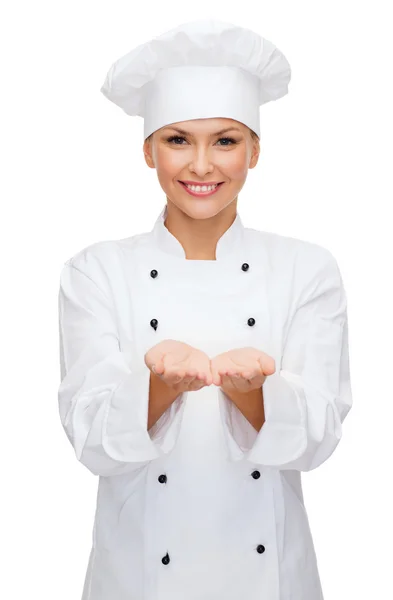 Sorridente chef femminile che tiene qualcosa sulle mani — Foto Stock